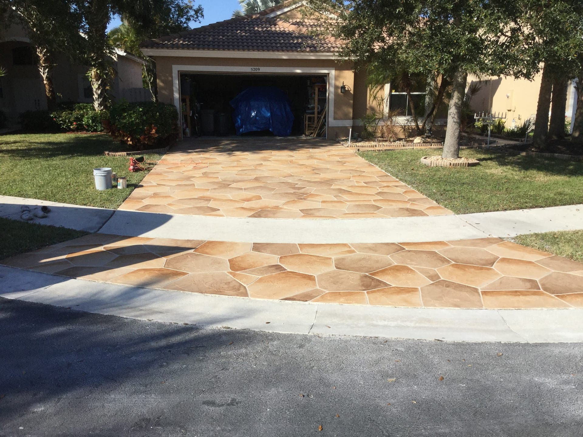 Tan flagstone driveway with palm trees